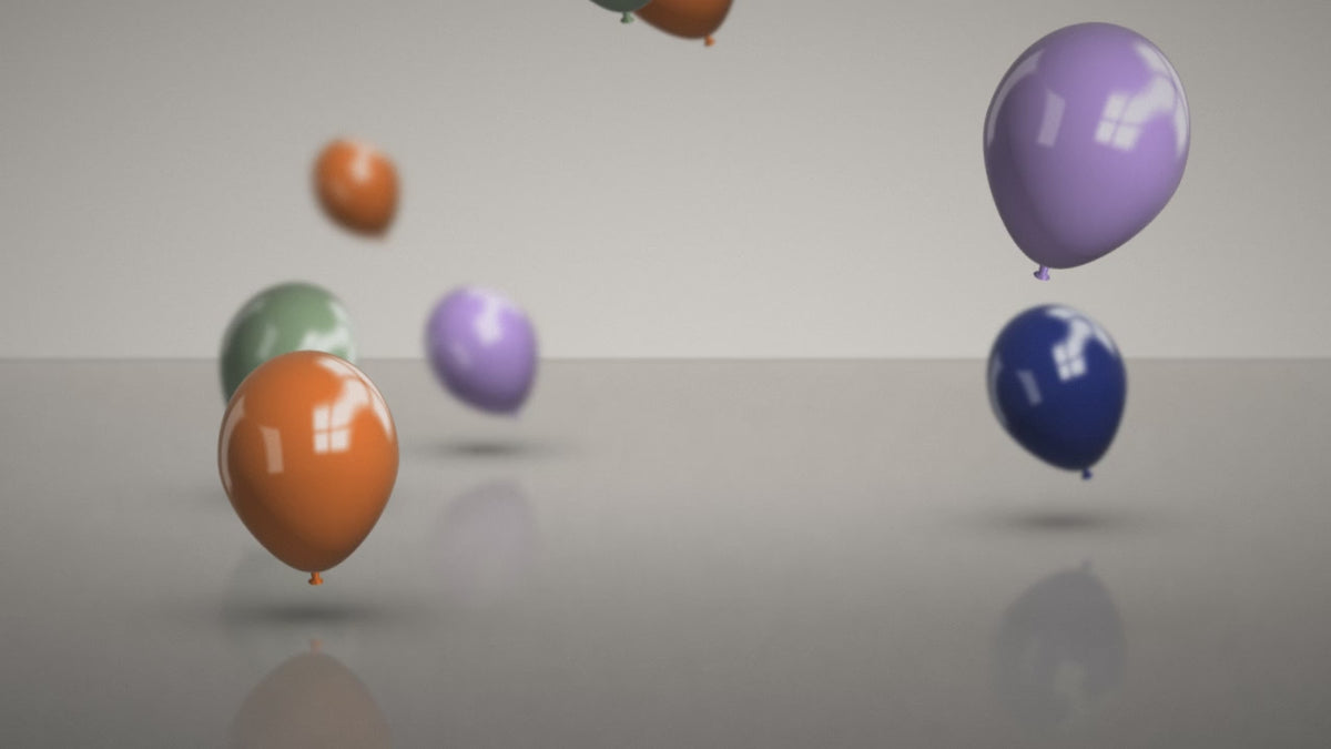 bouncing orange, blue, sage, and navy balloons in an empty room